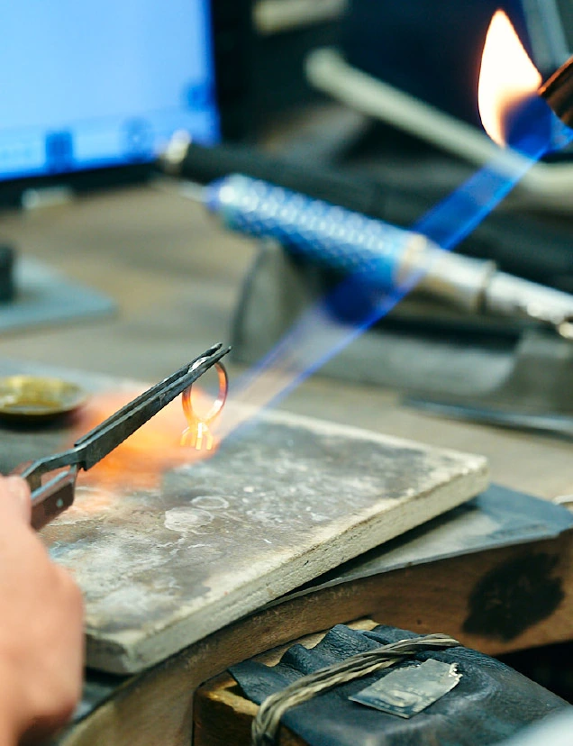 Gros plan d’une opération de soudure au chalumeau sur un établi des Ateliers GEM.